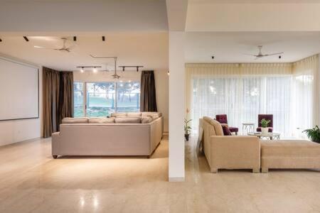 a large living room with two couches and a table at Golf View Home by JadeCaps 4BHK with Breakfast in Hosūr