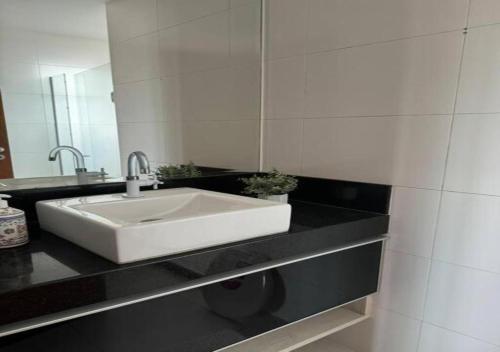 a bathroom with a white sink and a mirror at Espaço inteiro - Apto 2 quartos em Jardim Camburi, Vitória-ES in Vitória