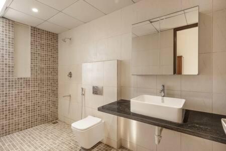 a white bathroom with a sink and a toilet at Golf View Home by JadeCaps 4BHK with Breakfast in Hosūr