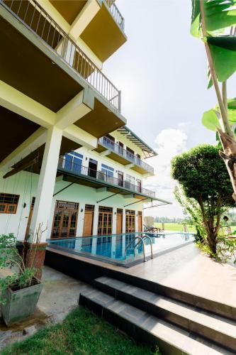 a building with a swimming pool in front of it at Serene Park Hotel By Ark in Tissamaharama