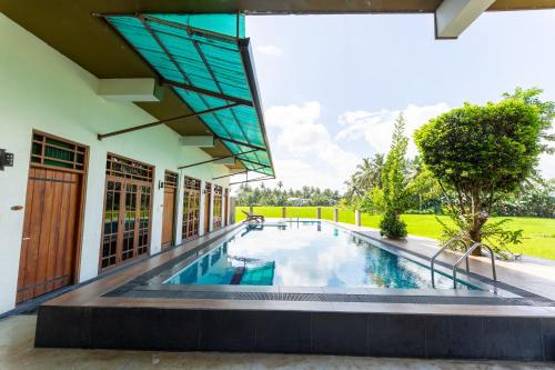 an external view of a house with a swimming pool at Serene Park Hotel By Ark in Tissamaharama