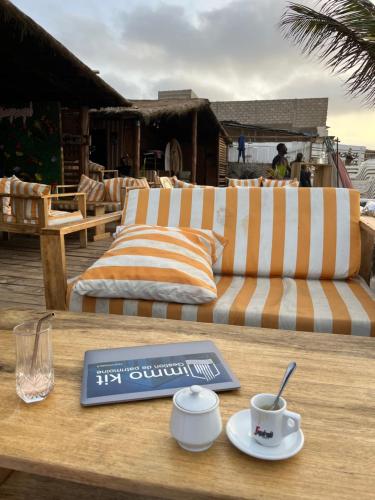a table with a book and a cup of coffee on it at Maison confortable élégante et équipée pour un séjour idéal à Dakar in Dakar
