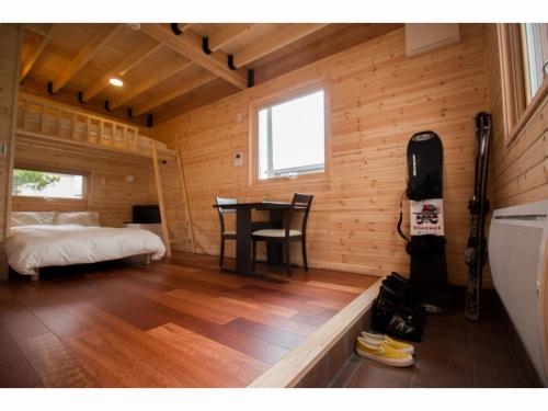 a bedroom with a bed and a table in a room at Brick House Furano in Furano