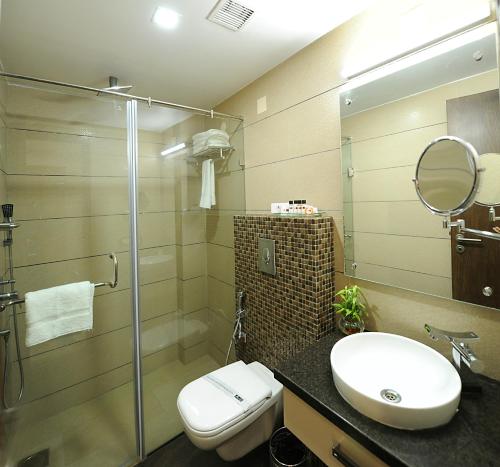 a bathroom with a toilet and a sink and a shower at Hotel Abode in Amritsar