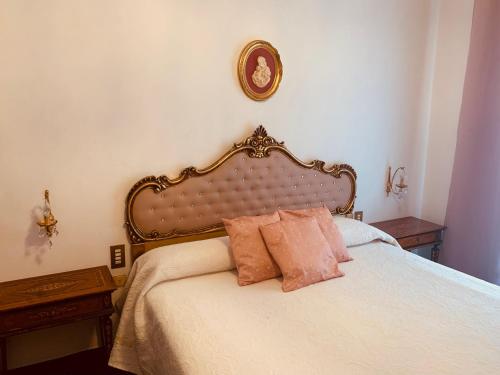 a bedroom with a large bed with pink pillows at MAISON IVA & GIO' OLD STYLE in Genoa