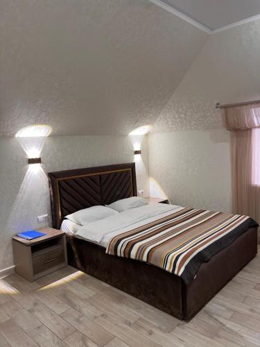 a bedroom with a bed with two lights on it at Гостинично-банный комплекс Майами Люкс in Kostanay