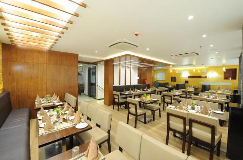 a restaurant with tables and chairs in a room at Hotel Abode in Amritsar
