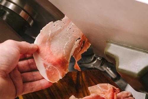a person holding a piece of meat on a cutting board at Mercure Kochi Tosa Resort & Spa in Geisei