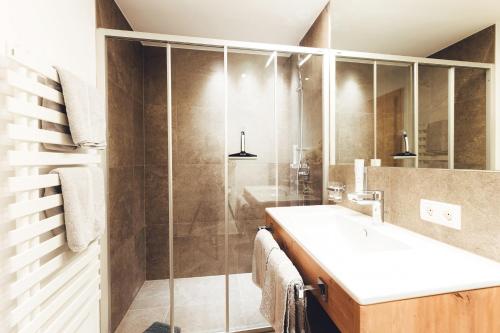 a bathroom with a sink and a shower at Burgstadl Aparthotel & Restaurant in Ladis