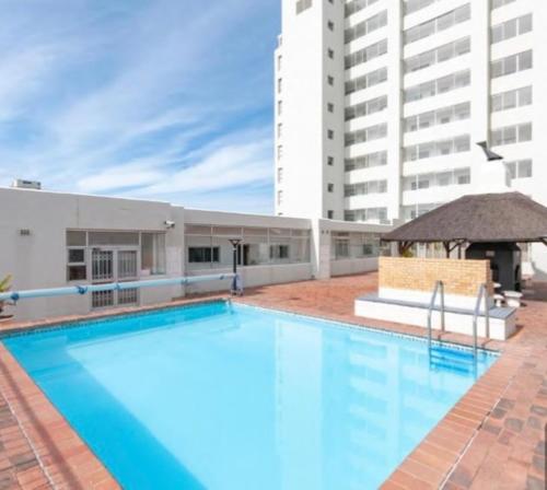 a large swimming pool in front of a building at Likizo apartment in Strand