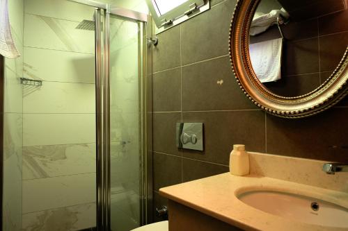 a bathroom with a shower and a sink and a mirror at Taksim Celebi Suites in Istanbul