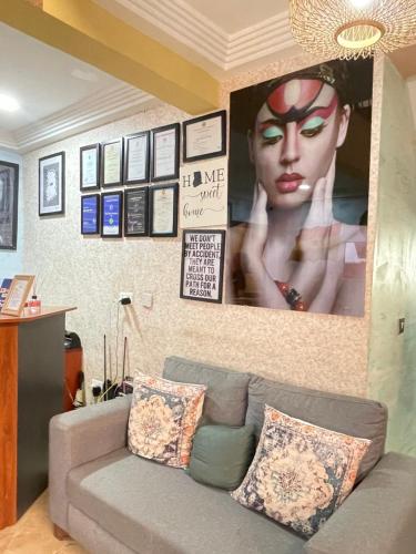 a living room with a couch and a poster on the wall at Bays Lodge, Accra in Accra