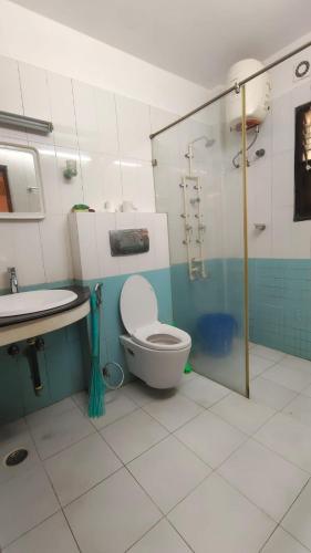 a bathroom with a toilet and a sink and a shower at HACIENDA APARTMENT in Chennai