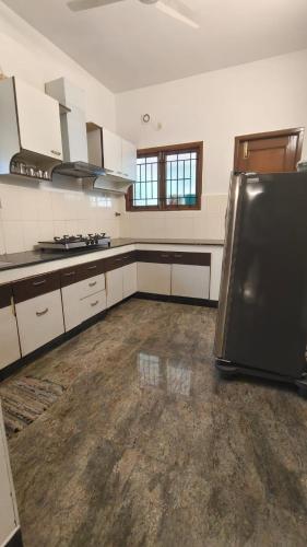a kitchen with a black refrigerator in a room at HACIENDA APARTMENT in Chennai