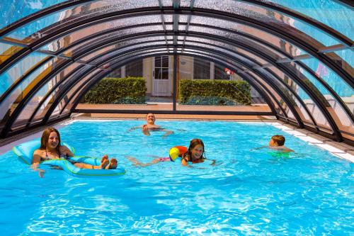 a group of children swimming in a swimming pool at Ferienanlage - Zum See & Hotel in Plau am See