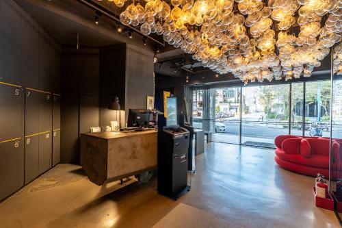 a lobby with a red couch and a chandelier at CHECK inn Taichung Liming in Taichung