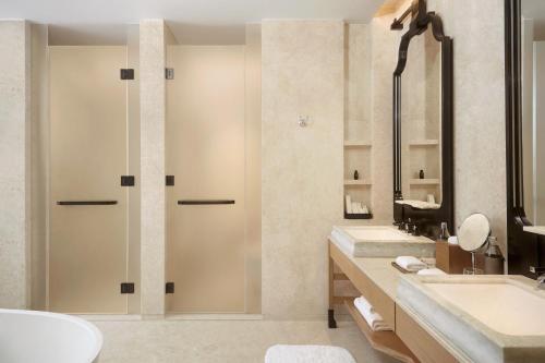 a bathroom with a shower and a sink at Dusit Thani Bangkok in Bangkok