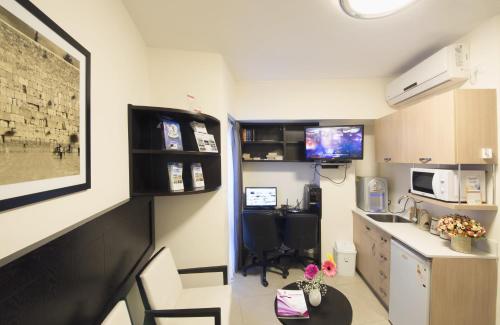 
a kitchen with a refrigerator and a microwave at Shamai Suites Jerusalem in Jerusalem
