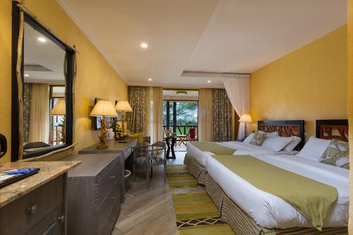 a hotel room with a large bed and a desk at Sawela Lodges in Naivasha