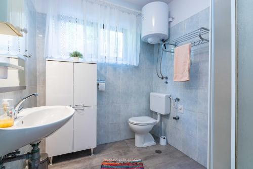 a bathroom with a white sink and a toilet at Apt ANA, Vantacici-Malinska, Island Krk in Vantačići