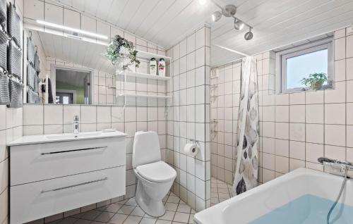 y baño con bañera, aseo y lavamanos. en Nice Home In Oksbl With Kitchen, en Oksbøl