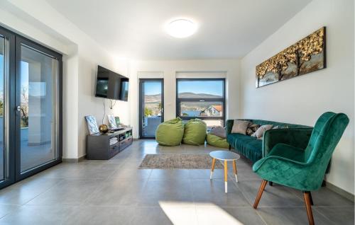 a living room with a green couch and a chair at Beach Front Home In Pridraga in Pridraga