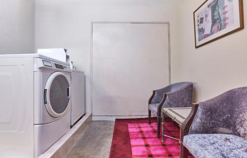 a laundry room with a washing machine and a chair at Village Hotel Albert Court by Far East Hospitality in Singapore
