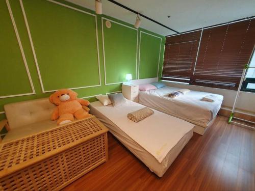 une chambre avec deux lits et un ours en peluche assis sur un banc dans l'établissement Private house near Hongdae with Elevator, à Séoul