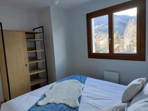 a bedroom with a bed and a window at Le Chalet des O in Saint-Lary-Soulan