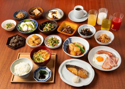 einen Tisch mit Teller mit Lebensmitteln und Schüsseln mit Lebensmitteln in der Unterkunft Sotetsu Hotels The Splaisir Yokohama in Yokohama
