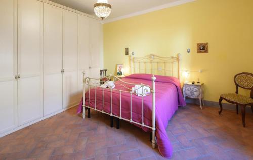 um quarto com uma cama com um edredão rosa em 2 Bedroom Pet Friendly Apartment In Bibbiena em Bibbiena