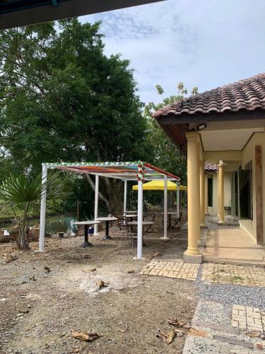 a pavilion with a picnic table and a bench at Rumah Madu Tiga Kangar in Kangar