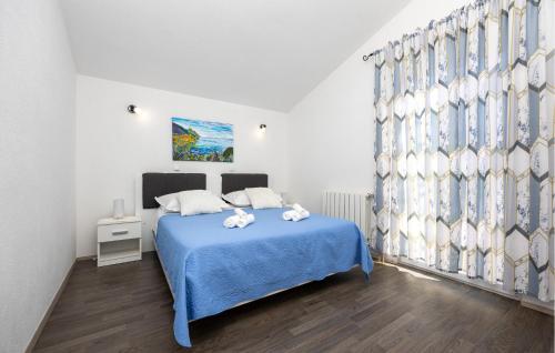 a bedroom with a blue bed with a blue blanket at Amazing Apartment In Slime With Wifi in Slime