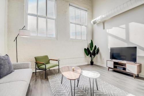 a living room with a couch and a tv at CozySuites - 2BR with Direct Skybridge Access #9 in Indianapolis