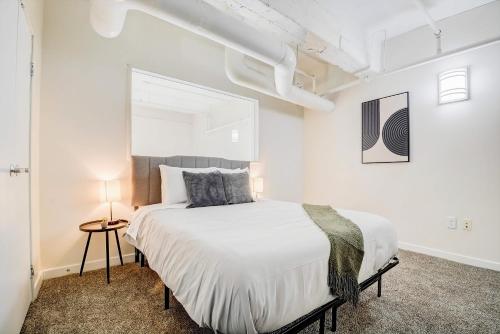 a bedroom with a large bed in a white room at CozySuites - 2BR with Direct Skybridge Access #9 in Indianapolis
