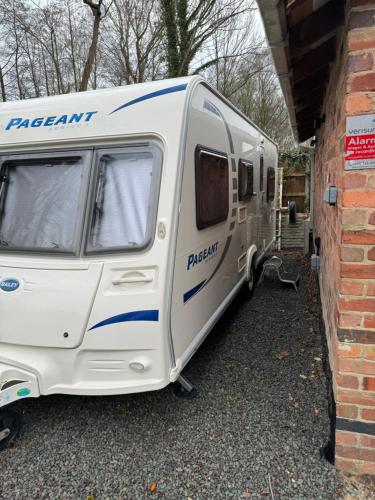 a white caravan parked next to a brick building at 2 bedroom caravan with gated access in Broseley