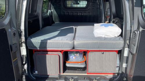 an open trunk of a van with a bed in it at Electric London Black Minicamper in Bergen