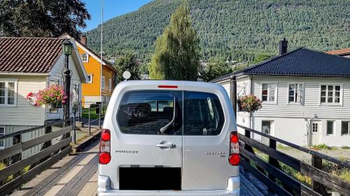 a white van parked on a street with houses at Electric London Black Minicamper in Bergen