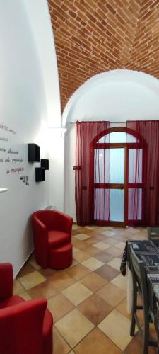 a living room with a red chair and a table at La Casa di Trilly in Vigevano
