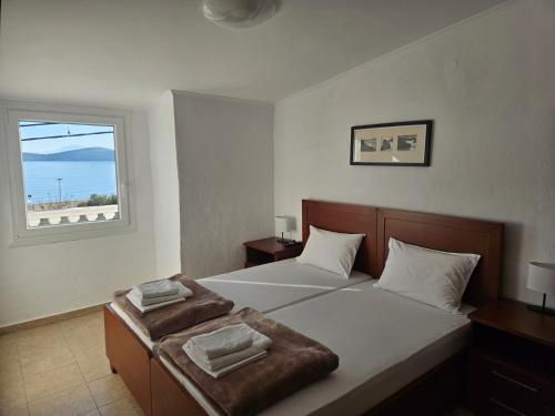 a bedroom with a large bed with a window at Leonidas Apartments in Nea Peramos