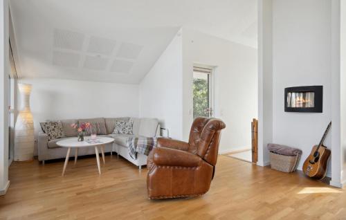a living room with a leather chair and a couch at Cozy Home In Børkop With Wifi in Børkop
