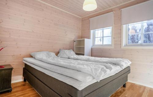 Cama grande en habitación con paredes de madera en Stunning Home In Farsund With House Sea View, en Farsund