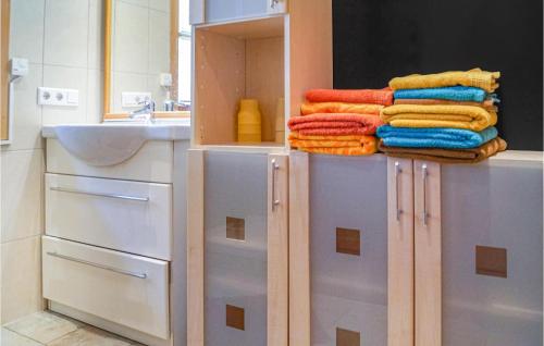 a bathroom with a stack of towels and a sink at Beautiful Home In Mayrhofen With 3 Bedrooms in Mayrhofen