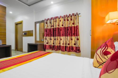 - une chambre avec un lit et un rideau dans l'établissement Hotel Intourist Palace, à Itahari