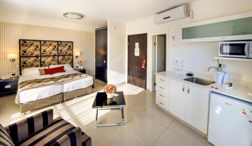 a bedroom with a bed and a kitchen with a sink at Shamai Suites Jerusalem in Jerusalem