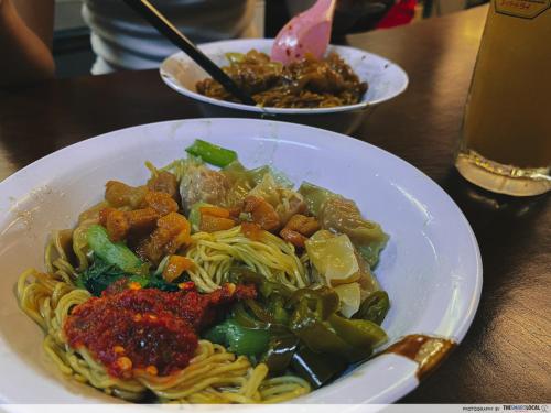a plate of pasta with meat and vegetables on a table at Stewart Hotel at 67 By EVR - Newly Renovated 2024 in George Town