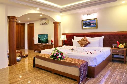 a bedroom with a large bed with flowers on it at Apus Hotel in Nha Trang