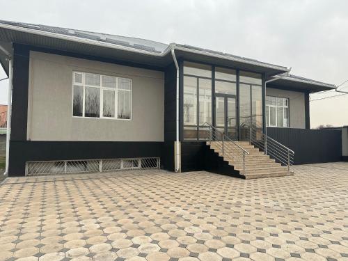 una casa con muchas ventanas y un patio en Sunny Hostel, en Osh