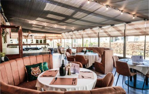 a restaurant with tables and chairs and windows at Awesome StaCaravan In Harderwijk in Harderwijk