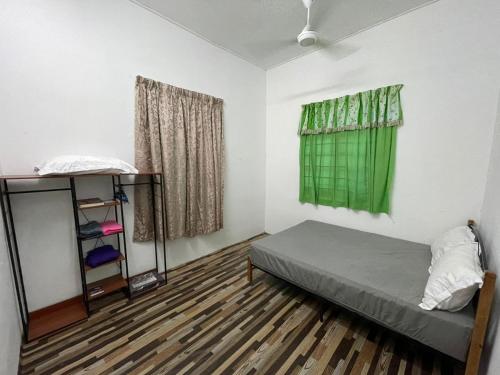 een kleine kamer met een bed en een raam bij Teratak Zaa D’Homestay in Kota Bharu